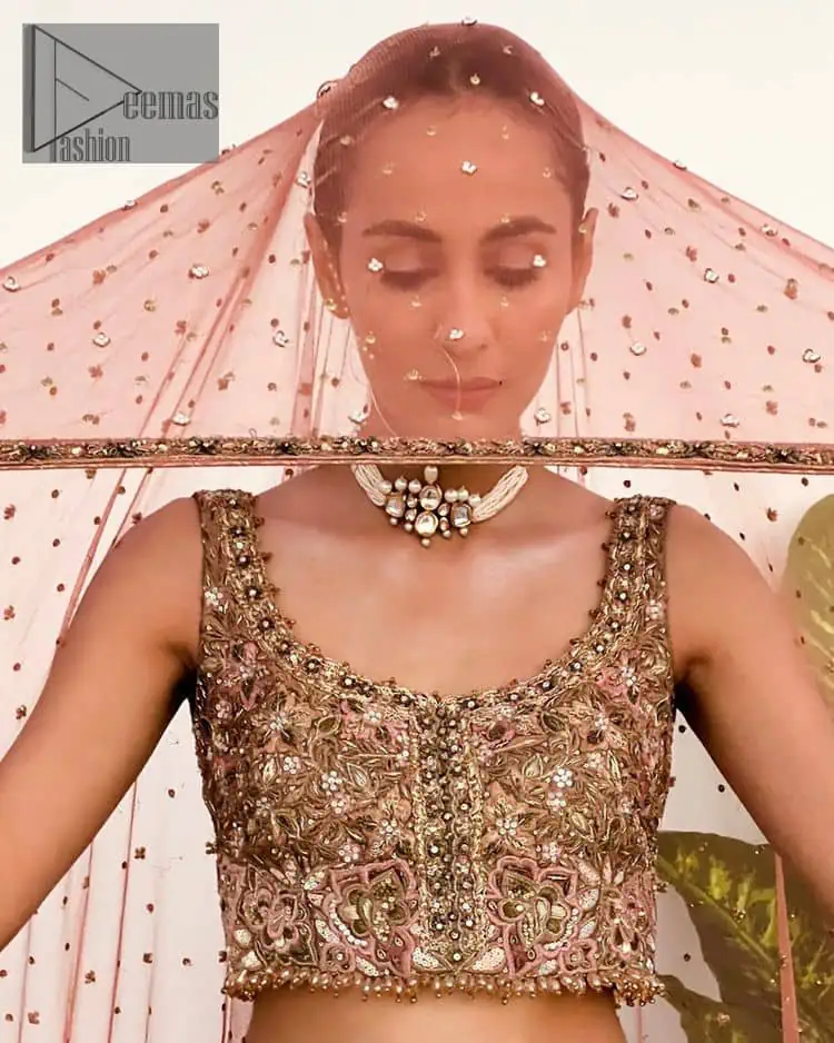 The perfect outfit for walima to enhance your glow. Starting this article with a dream rust blouse having a strap neckline and prominent sleeveless style to embrace the romantic culture. The following blouse is fully embellished with golden embroidery that is prominent with tilla, dabka, kora, pearls and sequins spray to fulfil your dreamy look. It is coordinated with an ivory can-can lehenga whose border is again rendered with golden embroidery and sequins sprayed all over to continue the look. Complete this outfit with a rust dupatta which is embellished with four-sided borders and sequins sprayed all over to enhance the glow of the bride.