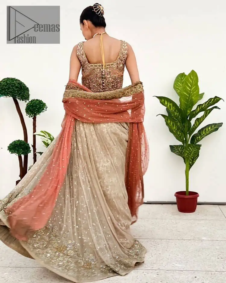 The perfect outfit for walima to enhance your glow. Starting this article with a dream rust blouse having a strap neckline and prominent sleeveless style to embrace the romantic culture. The following blouse is fully embellished with golden embroidery that is prominent with tilla, dabka, kora, pearls and sequins spray to fulfil your dreamy look. It is coordinated with an ivory can-can lehenga whose border is again rendered with golden embroidery and sequins sprayed all over to continue the look. Complete this outfit with a rust dupatta which is embellished with four-sided borders and sequins sprayed all over to enhance the glow of the bride.