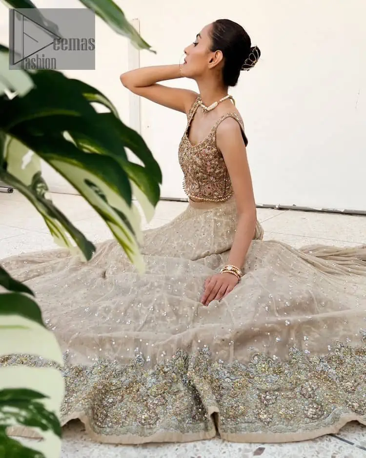 The perfect outfit for walima to enhance your glow. Starting this article with a dream rust blouse having a strap neckline and prominent sleeveless style to embrace the romantic culture. The following blouse is fully embellished with golden embroidery that is prominent with tilla, dabka, kora, pearls and sequins spray to fulfil your dreamy look. It is coordinated with an ivory can-can lehenga whose border is again rendered with golden embroidery and sequins sprayed all over to continue the look. Complete this outfit with a rust dupatta which is embellished with four-sided borders and sequins sprayed all over to enhance the glow of the bride.