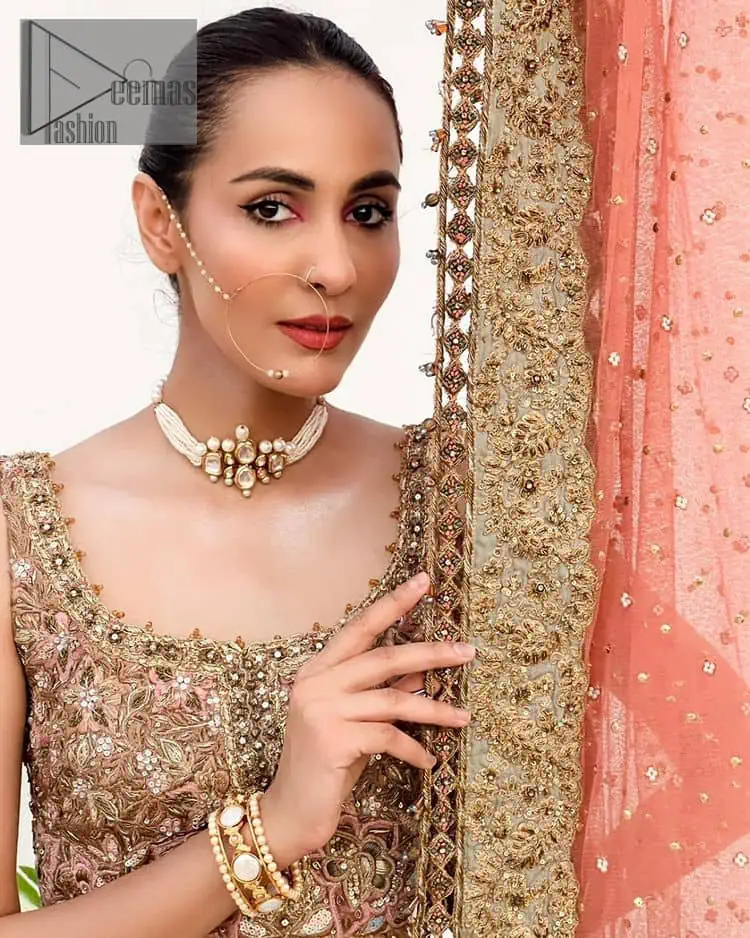 The perfect outfit for walima to enhance your glow. Starting this article with a dream rust blouse having a strap neckline and prominent sleeveless style to embrace the romantic culture. The following blouse is fully embellished with golden embroidery that is prominent with tilla, dabka, kora, pearls and sequins spray to fulfil your dreamy look. It is coordinated with an ivory can-can lehenga whose border is again rendered with golden embroidery and sequins sprayed all over to continue the look. Complete this outfit with a rust dupatta which is embellished with four-sided borders and sequins sprayed all over to enhance the glow of the bride.