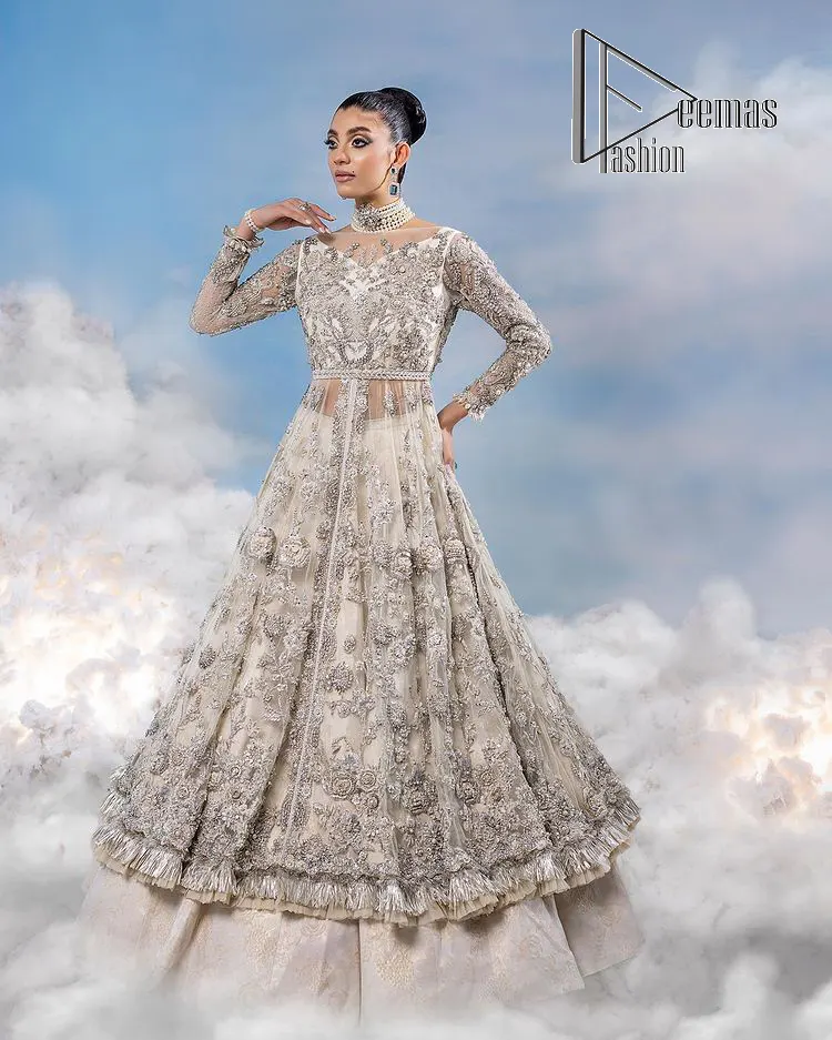 The mind wears the colours of the soul, as a beige of those of his master. Starting this nikah outfit with a beige frilled maxi which is laboriously hand-rendered with silver embroidery to fulfil the fairy dream of every bride. Furthermore, it is enhanced with tilla, dabka, kora and crystal which magnifies the beauty of this nikah outfit. The illusion neckline looks as amazing when comes with full sleeves as the moon with stars. The maxi of this nikah outfit is systemized with a lehenga in the same colour which is proof of uniqueness. Complete this nikah outfit with a dupatta in the same colour having a four-sided embellished border and sequins sprayed all over.    