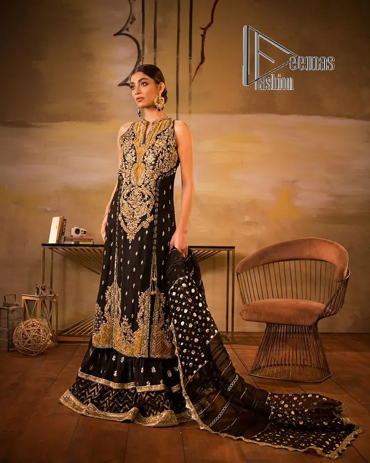 Black is just a vibe in any kind of party. DeemasFashion presents a luscious black base that serves as a canvas for a gorgeous long shirt which is beautifully decorated with light golden embroidery. The fascinating embroidery vague the terms tilla, kora, dabka and zardozi to make your party a shining one. Further, the sleeveless style of the long shirt gives a romantic look to the party wear. It is coordinated with black sharara which is again ornamented with light golden embroidery . In parallel to the shirt and sharara, the dupatta in the same colour is also embellished with four-sided borders as well. 