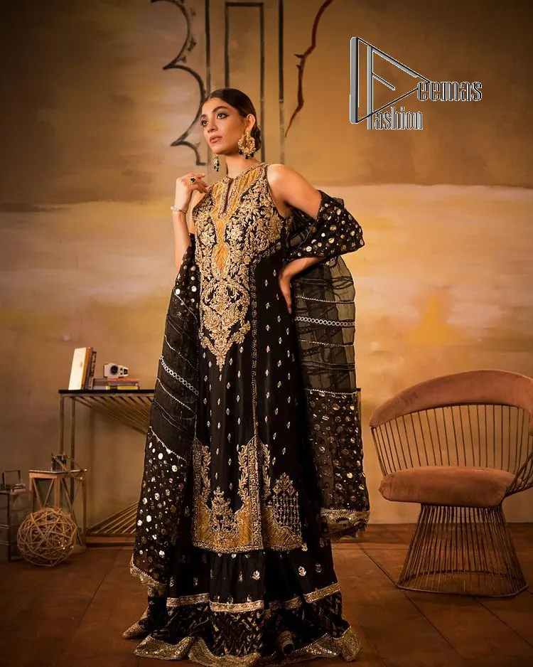 Black is just a vibe in any kind of party. DeemasFashion presents a luscious black base that serves as a canvas for a gorgeous long shirt which is beautifully decorated with light golden embroidery. The fascinating embroidery vague the terms tilla, kora, dabka and zardozi to make your party a shining one. Further, the sleeveless style of the long shirt gives a romantic look to the party wear. It is coordinated with black sharara which is again ornamented with light golden embroidery . In parallel to the shirt and sharara, the dupatta in the same colour is also embellished with four-sided borders as well. 