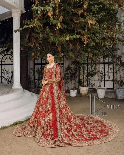 Feels just redish on your Big day to make your day lovely and romantic. DeemasFashion presents this Pakistani reception wear for you in bright red colour which begins with a flared back train maxi. The maxi is attractively and laboriously adorned with golden embroidery that enhances tilla,dabka, kora and Kundan. In addition to this, the boat shape neckline intensifies the beauty of this Pakistani reception wear when comes with full sleeves. The flared back train of the maxi is also heavily embellished. Complete this article with a dupatta in the same colour which is adorned with four-sided borders and tiny floral motifs, sequins spray all over to make you fresh on your Big day.