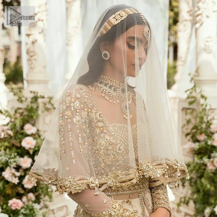 Mark your Nikah day in a calendar as a special one with this marvellous outfit. DeemasFashion presents this outfit in light fawn colour which begins with a back train scalloped maxi. The following maxi is sumptuously embellished with a golden embroidery which is further intensified with tilla, dabka, naqshi, Resham and zardozi. The sweetheart neckline of the maxi is heavily embellished and looks romantic when comes with full sleeves style. It is handsomely paired up with a lehenga in the same colour which is so plain to balance the look of the outfit. Finish this article with a scalloped dupatta which is embellished with four-sided borders and sequins sprayed all over to make your day more magical. 