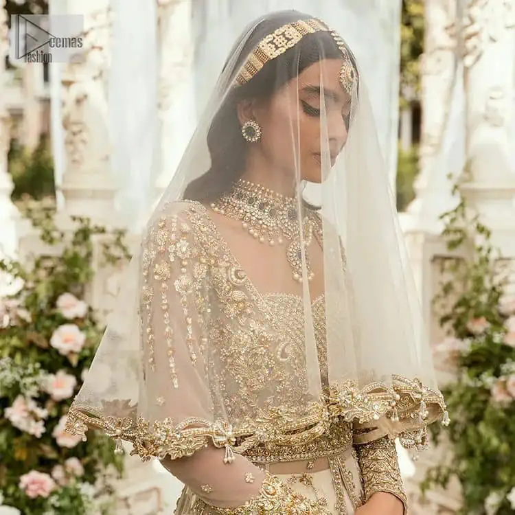 Mark your Nikah day in a calendar as a special one with this marvellous outfit. DeemasFashion presents this outfit in light fawn colour which begins with a back train scalloped maxi. The following maxi is sumptuously embellished with a golden embroidery which is further intensified with tilla, dabka, naqshi, Resham and zardozi. The sweetheart neckline of the maxi is heavily embellished and looks romantic when comes with full sleeves style. It is handsomely paired up with a lehenga in the same colour which is so plain to balance the look of the outfit. Finish this article with a scalloped dupatta which is embellished with four-sided borders and sequins sprayed all over to make your day more magical.