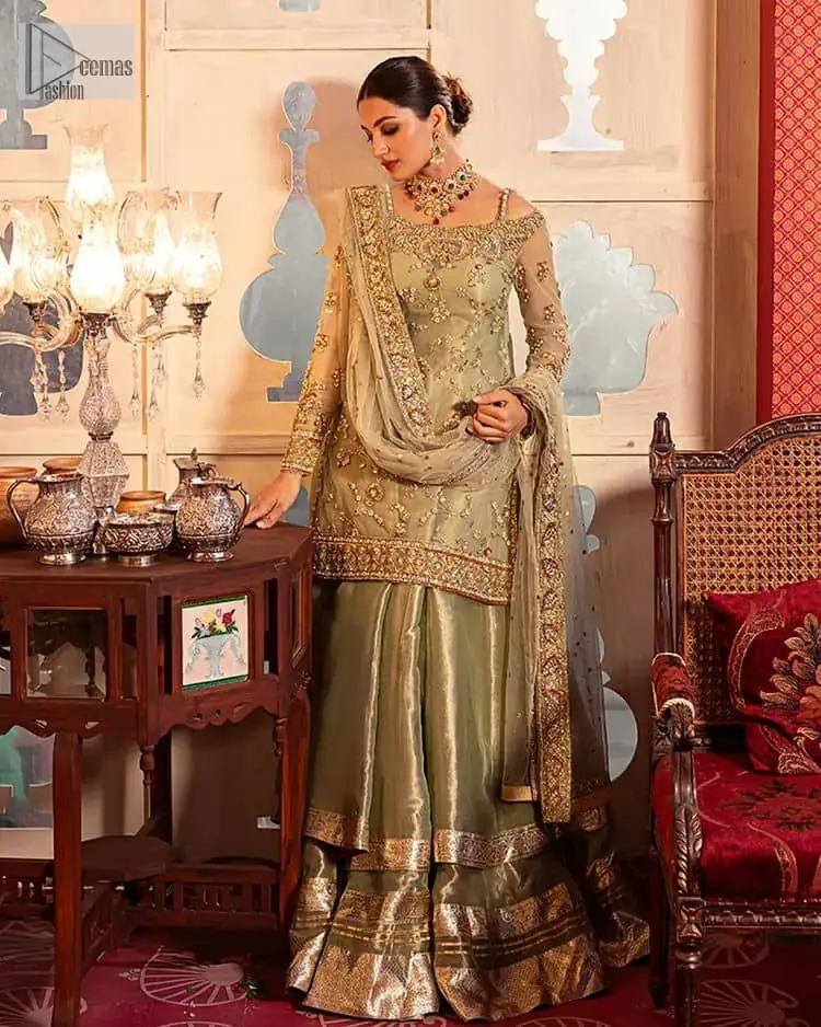 A refreshing colour palette that will make your eyes twinkle and heart sing! A pure organza short shirt in olive green is attractively hand-rendered with golden embroidery and is enhanced with naqshi, Sitara, dabka, tilla, and Zardozi. The strap neckline of this amazing shirt comes with full sleeves to make your Mehndi event more delightful and stunning. The following shirt is paired with double layered lehenga which is just in plane mode to balance the outfit. Complete this traditional look with a dupatta with sequins sprayed all over, framed with a gorgeous embellished four-sided border.