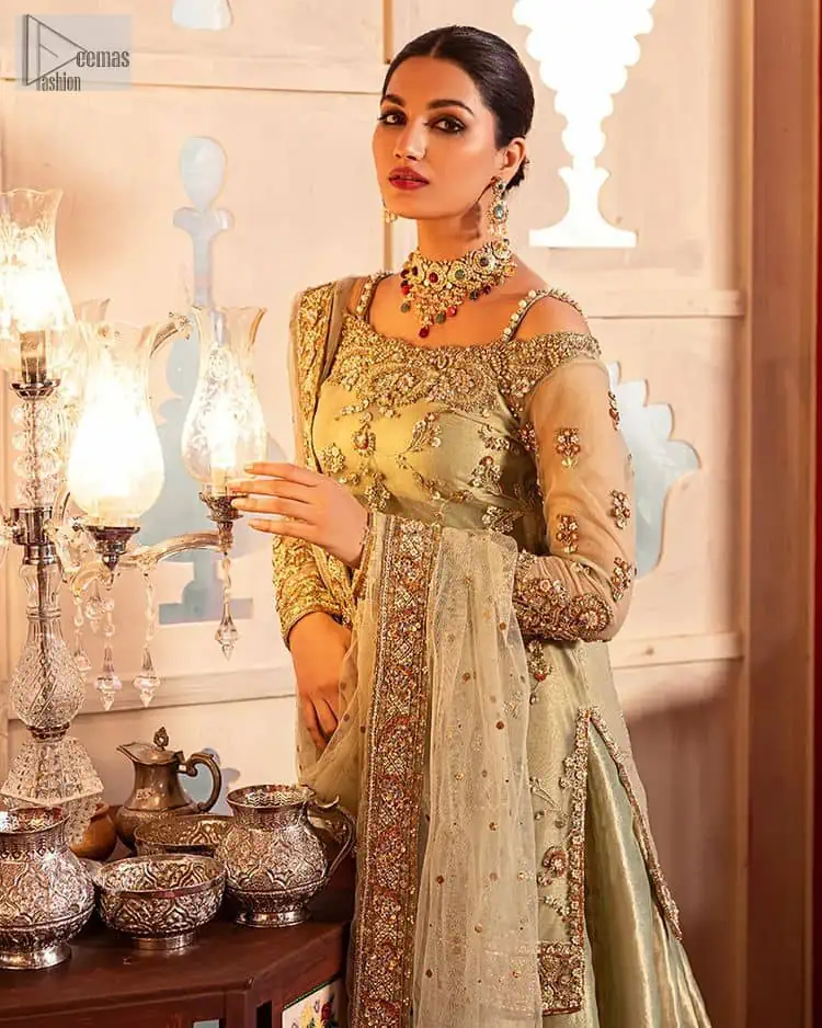 A refreshing colour palette that will make your eyes twinkle and heart sing! A pure organza short shirt in olive green is attractively hand-rendered with golden embroidery and is enhanced with naqshi, Sitara, dabka, tilla, and Zardozi. The strap neckline of this amazing shirt comes with full sleeves to make your Mehndi event more delightful and stunning. The following shirt is paired with double layered lehenga which is just in plane mode to balance the outfit. Complete this traditional look with a dupatta with sequins sprayed all over, framed with a gorgeous embellished four-sided border.
