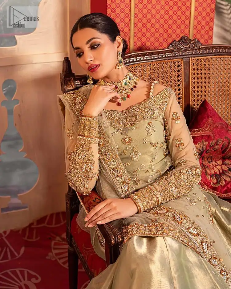A refreshing colour palette that will make your eyes twinkle and heart sing! A pure organza short shirt in olive green is attractively hand-rendered with golden embroidery and is enhanced with naqshi, Sitara, dabka, tilla, and Zardozi. The strap neckline of this amazing shirt comes with full sleeves to make your Mehndi event more delightful and stunning. The following shirt is paired with double layered lehenga which is just in plane mode to balance the outfit. Complete this traditional look with a dupatta with sequins sprayed all over, framed with a gorgeous embellished four-sided border.