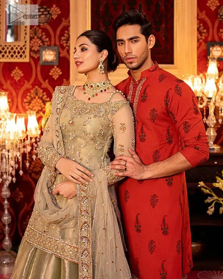 A refreshing colour palette that will make your eyes twinkle and heart sing! A pure organza short shirt in olive green is attractively hand-rendered with golden embroidery and is enhanced with naqshi, Sitara, dabka, tilla, and Zardozi. The strap neckline of this amazing shirt comes with full sleeves to make your Mehndi event more delightful and stunning. The following shirt is paired with double layered lehenga which is just in plane mode to balance the outfit. Complete this traditional look with a dupatta with sequins sprayed all over, framed with a gorgeous embellished four-sided border.