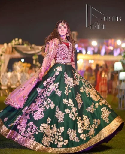 A combination of red and green are here to win hearts at your Mehndi. The attractive lehenga in green colour is hand-rendered with golden embroidery and enhanced with tilla, dabka, kora and zardozi. The floral pattern of the lehenga is followed by attractive border embroidery. It is paired up with a red blouse choli which is beautifully embellished and enhanced with V shape neckline. Further, the half sleeves style of the blouse also added beauty to this outfit. Finish this outfit with a dupatta which is ornamented with four-sided borders and floral motifs all over.