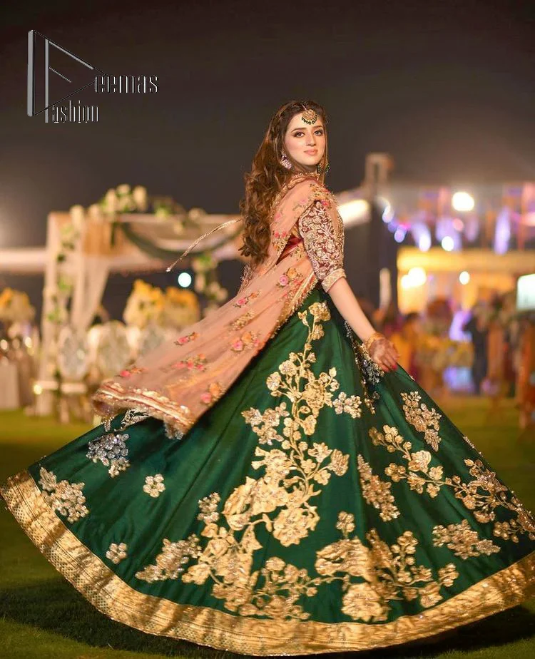 A combination of red and green are here to win hearts at your Mehndi. The attractive lehenga in green colour is hand-rendered with golden embroidery and enhanced with tilla, dabka, kora and zardozi. The floral pattern of the lehenga is followed by attractive border embroidery. It is paired up with a red blouse choli which is beautifully embellished and enhanced with V shape neckline. Further, the half sleeves style of the blouse also added beauty to this outfit. Finish this outfit with a dupatta which is ornamented with four-sided borders and floral motifs all over.
