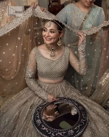 Regal and Charismatic - This is all the outfit is about! A desirable beige lehenga and choli are entirely heavily embroidered with silver colour and embellished with sequins, tilla, naqshi, Zardozi and Dabka. Its stunning heavily embellished blouse has full sleeves and the blouse consists of V shape neckline. It is coordinated with flared lehenga which is adorned with beautiful embroidery to make this walima wear balance. Finish this with a dupatta that has silver sequin and tiny floral motifs all over. The dupatta is framed with a four-sided embellished border to make this masterpiece unique and attractive.