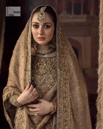 This alluring outfit is surely any girl’s dream. The hazel blouse is a magnificent choice which is ornamented with golden embroidery that wins everyone's hearts at the very first glance. It is further intensified with tilla, dabka, kora, Kundan and stones. Hand-crafted details on the full sleeves of this beautiful nikah dress make it the epitome of beauty. It is coordinated with a lehenga which is decorated with the finest details that are your first priority for the wedding. The lehenga has a huge flare to fulfil the dreamy look. Complete this article with a dupatta that is adorned with four-sided embellished borders and sparkling sequins to make your day.