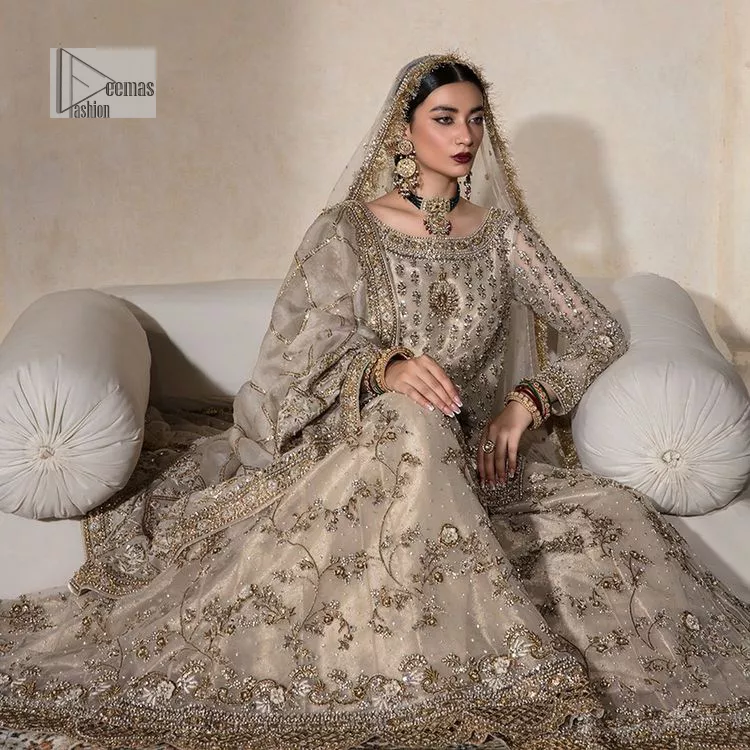 Unravel your inner density with our ivory nikah outfit. DeemasFashion presents this outfit which is embellished with light golden embroidery that further intensifies with tilla, dabka, kora, Kundan and the real magic of Zardozi. The ivory short shirt has boat shape neckline that is the epitome of royalty and grace. In addition to this, the embellished full sleeves also give a stunning touch to the shirt. It is coordinated with scalloped sharara making it a perfect choice to pair with the short shirt. Finish this outfit with a dupatta framed with four-sided embellished borders that gives you an impressive appearance on the Big day.