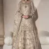 Unravel your inner density with our ivory nikah outfit. DeemasFashion presents this outfit which is embellished with light golden embroidery that further intensifies with tilla, dabka, kora, Kundan and the real magic of Zardozi. The ivory short shirt has boat shape neckline that is the epitome of royalty and grace. In addition to this, the embellished full sleeves also give a stunning touch to the shirt. It is coordinated with scalloped sharara making it a perfect choice to pair with the short shirt. Finish this outfit with a dupatta framed with four-sided embellished borders that gives you an impressive appearance on the Big day.