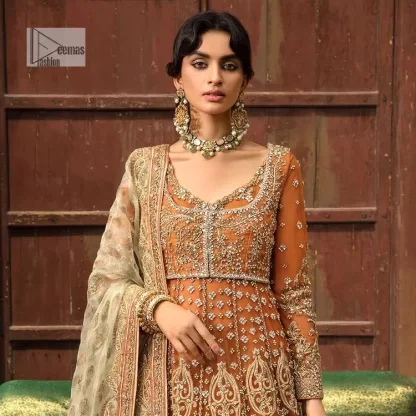 Let your dreams be your wings as your mehndi outfit. This rust heavy maxi features thoughtfully placed bold motifs all over and each motif is crafted using tilla, dabka, koran, Resham and Zardozi techniques. It is further enhanced with golden embroidery. The V shape neckline adds more beauty to the outfit when comes with embellished full sleeves. The beautiful outfit achieves the final ravishing look when paired with a delicate dupatta. The borders of this dupatta are heavily adorned with embroidery that gives a slaying touch to the whole attire.