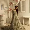 It was love at first swipe! Present this olive green back train maxi which is laboriously hand-rendered with silver embroidery to make you a pure soulful bride. It is enhanced with tilla, dabka, kora and Kundan. The illusion neckline adds more beauty to this walima wear when comes with full sleeves. The back train flare is made just for you to catch more and more love from your loved ones. Complete this walima wear with a dupatta in the same colour which is handsomely embellished with a four-sided heavy border and sequins sprayed all over to receive more love.