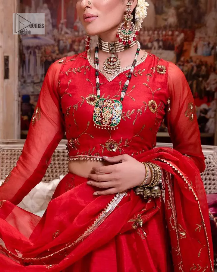 Statement suiting in red. This red blouse comes with a lehenga and dupatta in premium fabric quality. The blouse is beautifully decorated with fine embroidery work accompanied by iridescent sequins, tilla, dabka, kora and Zardozi. Furthermore, beautiful artistry on the neckline is highlighted with golden embroidery accompanied by cutwork counting more to the elegance of this luxurious attire. It is organized with a flared lehenga in the same colour. This embroidered lehenga comes is very neatly stitched and decorated with lavish embroidery and minimal floral motifs making this dreamy attire look heavenly and your ultimate priority. Complete this reception wear with a dupatta framed with four-sided embellished borders that is your favourite statement on your big day.