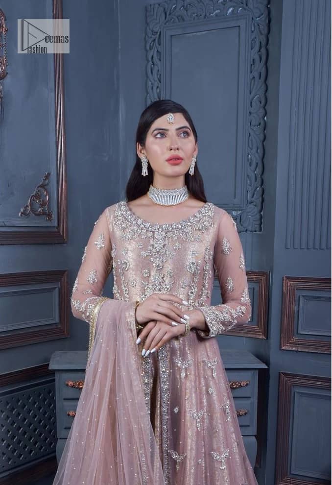 Have style and warmth with this tea rose nikah outfit! The front open maxi is the magic of floral motifs with engaging embellishments on the jamawar fabric, making this an eye-catching ensemble. The following maxi is adorned with tilla, dabka, Kora, Kundan and the real magic of Zardozi. The timeless silhouette is crafted, with floral motifs. The silver embellishments give a glamorous touch to this exquisite attire. In addition to this, the full sleeves are also decorated with floral motifs to make this article bright and charming. The round neckline also adds beauty to the overall look. Finish this article with a dupatta adorned with a four-sided borders and sequins sprayed all over for a perfect and classy look.