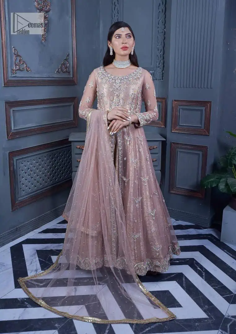 Have style and warmth with this tea rose nikah outfit! The front open maxi is the magic of floral motifs with engaging embellishments on the jamawar fabric, making this an eye-catching ensemble. The following maxi is adorned with tilla, dabka, Kora, Kundan and the real magic of Zardozi. The timeless silhouette is crafted, with floral motifs. The silver embellishments give a glamorous touch to this exquisite attire. In addition to this, the full sleeves are also decorated with floral motifs to make this article bright and charming. The round neckline also adds beauty to the overall look. Finish this article with a dupatta adorned with a four-sided borders and sequins sprayed all over for a perfect and classy look.