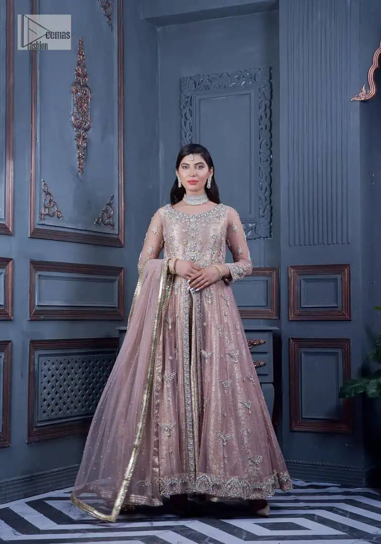 Have style and warmth with this tea rose nikah outfit! The front open maxi is the magic of floral motifs with engaging embellishments on the jamawar fabric, making this an eye-catching ensemble. The following maxi is adorned with tilla, dabka, Kora, Kundan and the real magic of Zardozi. The timeless silhouette is crafted, with floral motifs. The silver embellishments give a glamorous touch to this exquisite attire. In addition to this, the full sleeves are also decorated with floral motifs to make this article bright and charming. The round neckline also adds beauty to the overall look. Finish this article with a dupatta adorned with a four-sided borders and sequins sprayed all over for a perfect and classy look.