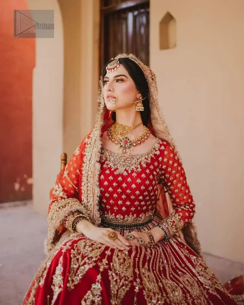 This unique red dress is a masterpiece of design, crafted with light golden and light antique shades of embroidery to