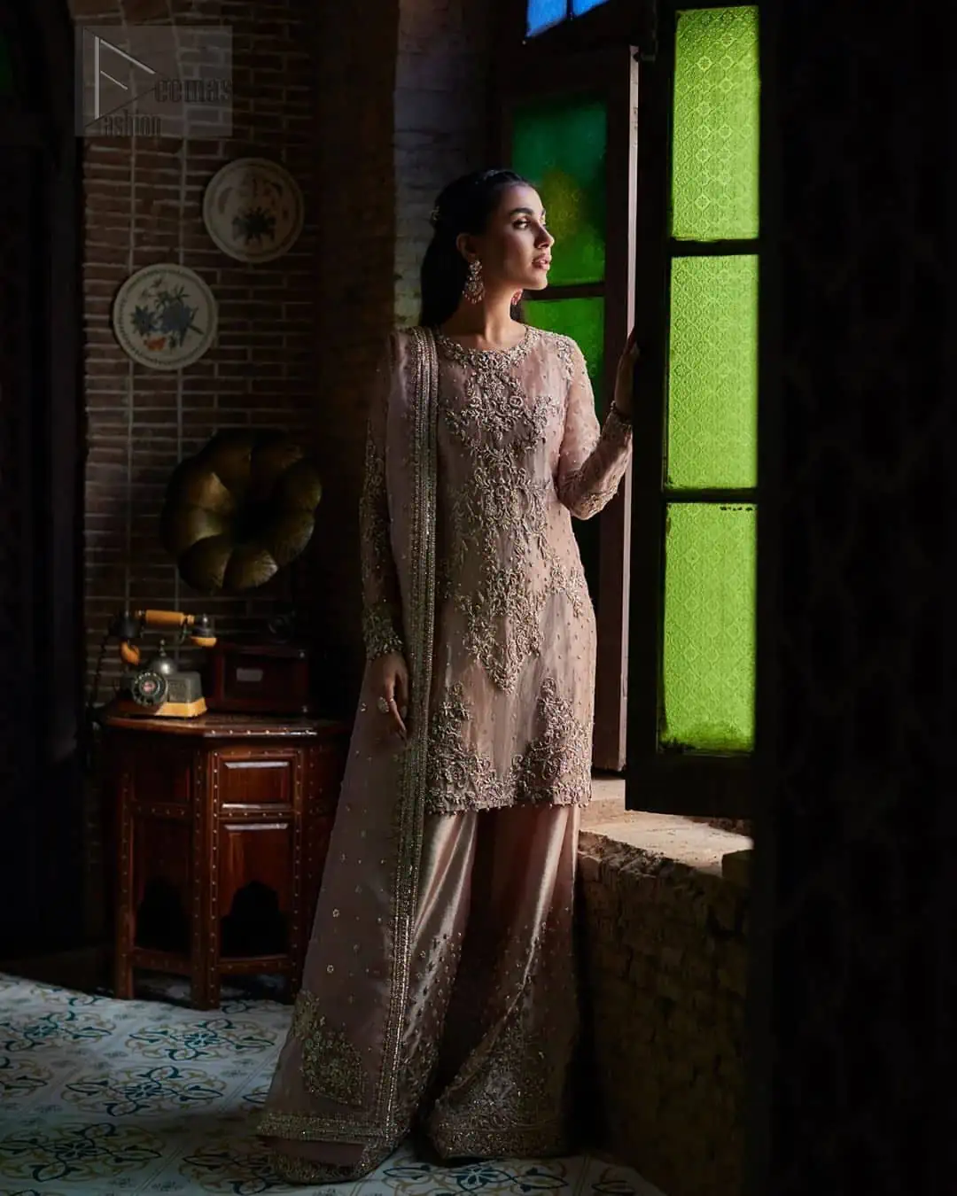 This elegant ensemble is thoughtfully designed with dark antique shades of embroidery which involves tilla, dabka, Kora, Kundan, and minimalist silhouette, allowing your natural beauty to shine on this sacred occasion. Crafted from the finest fabrics, it is organized with border embellished sharara that gives you grace as you exchange your vows.