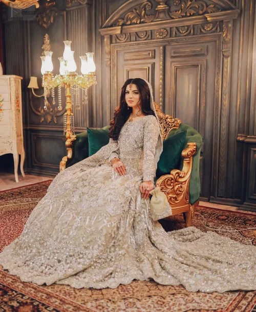 Adorned with delicate silver embroidery, the entire design glimmers with understated beauty. Crafted from organza and raw silk, this masterpiece