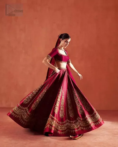 Flared Silhouette: Capturing the majestic volume and flare of the ruby red silk lehenga, perfect for first-day wedding celebrations.