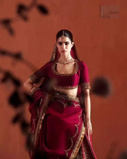 Movement Shot: The ruby red flared lehenga in motion, showing the weight and quality of the embellished silk fabric.